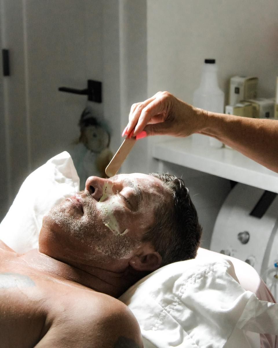 A woman is getting her eyebrows waxed in a beauty salon.