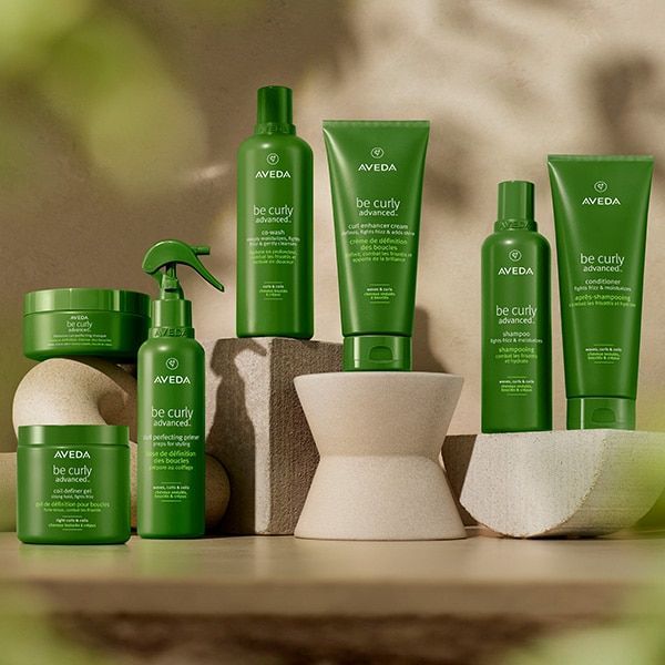 A variety of green aveda products are displayed on a table