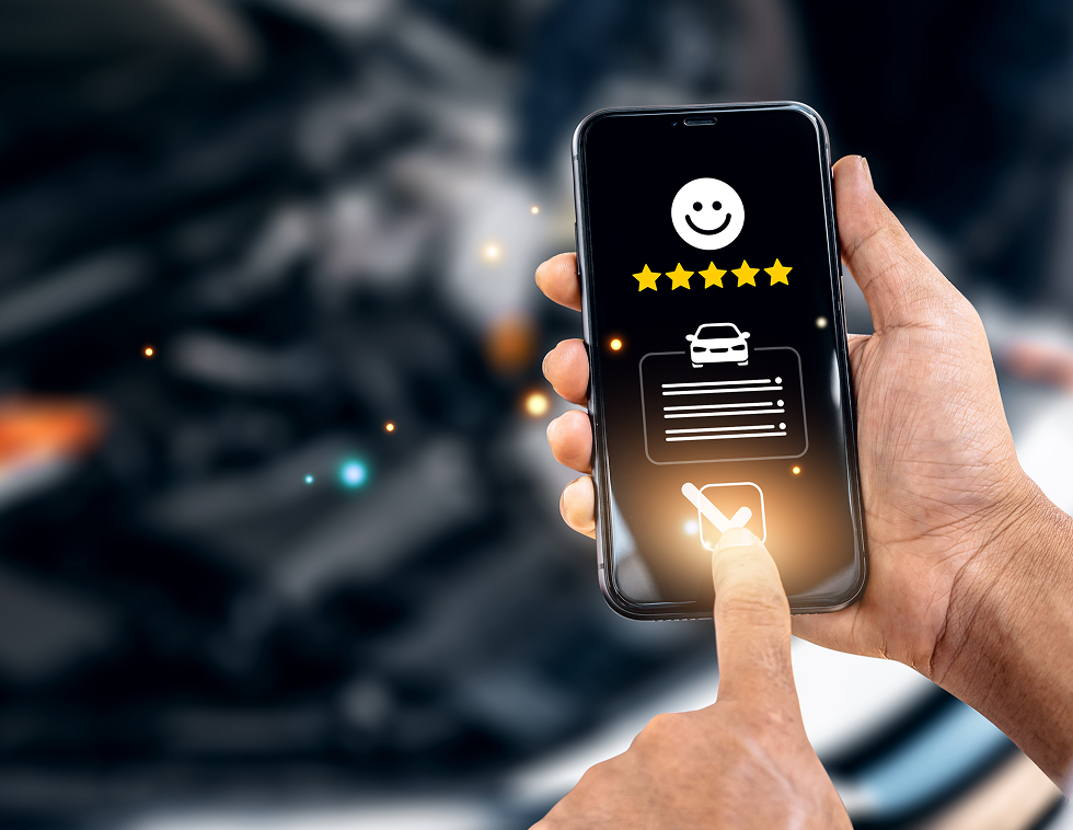 Hand holding phone, displaying a car service app with a 5-star rating, and pressing a checkmark - A&H Automotive Repair Shop