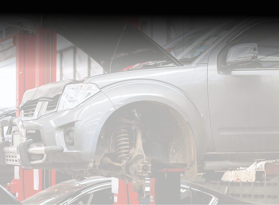 Silver truck raised on a lift in a repair shop, hood open for maintenance - A&H Automotive Repair Shop
