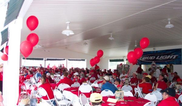 A bud light sign hangs above a crowd of people