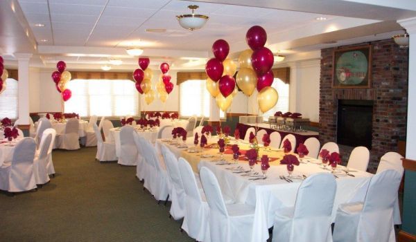 A room with tables and chairs and balloons hanging from the ceiling