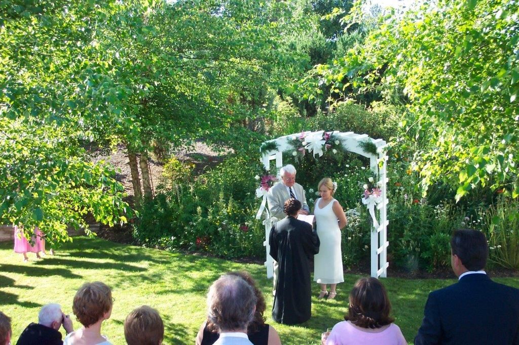 A bride and groom are getting married in front of a crowd of people.