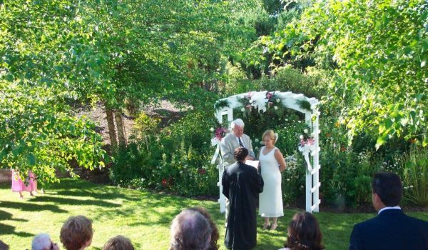 A bride and groom are getting married in front of a crowd of people.