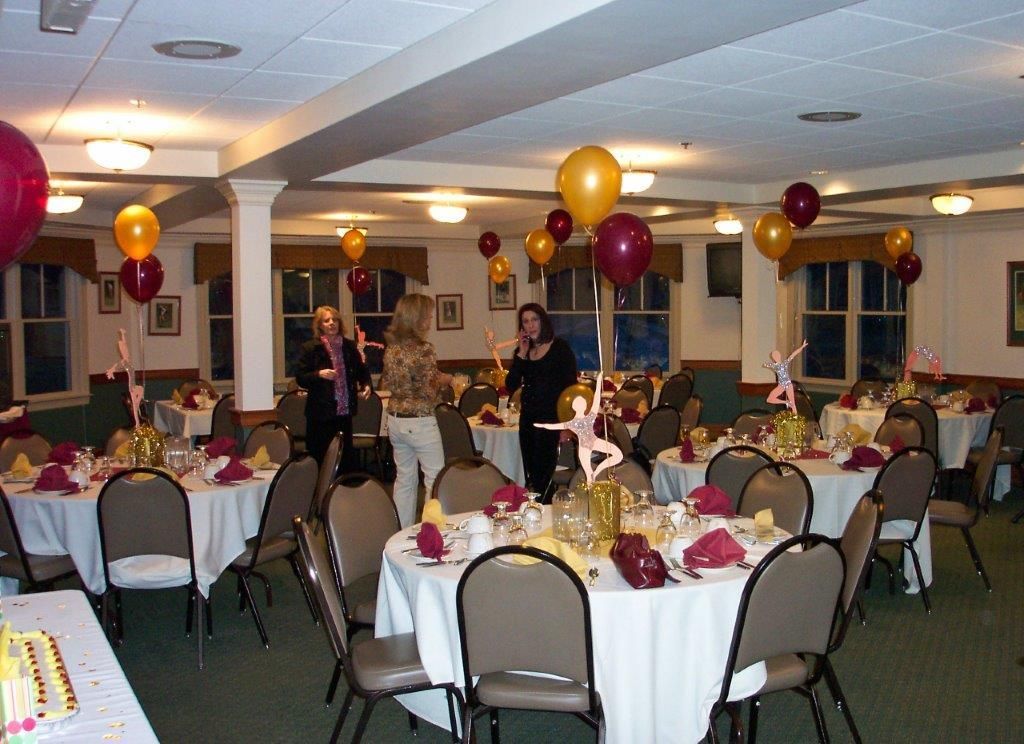 A large room with tables and chairs and balloons on the ceiling