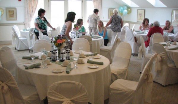 A large room with tables and chairs set up for a party