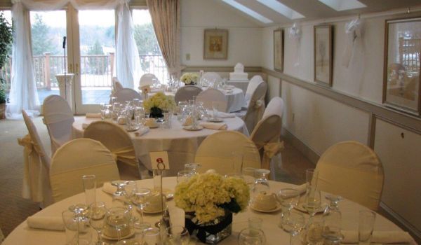 A room with tables and chairs set up for a wedding reception