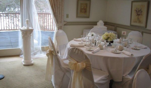 A room with tables and chairs set up for a wedding reception