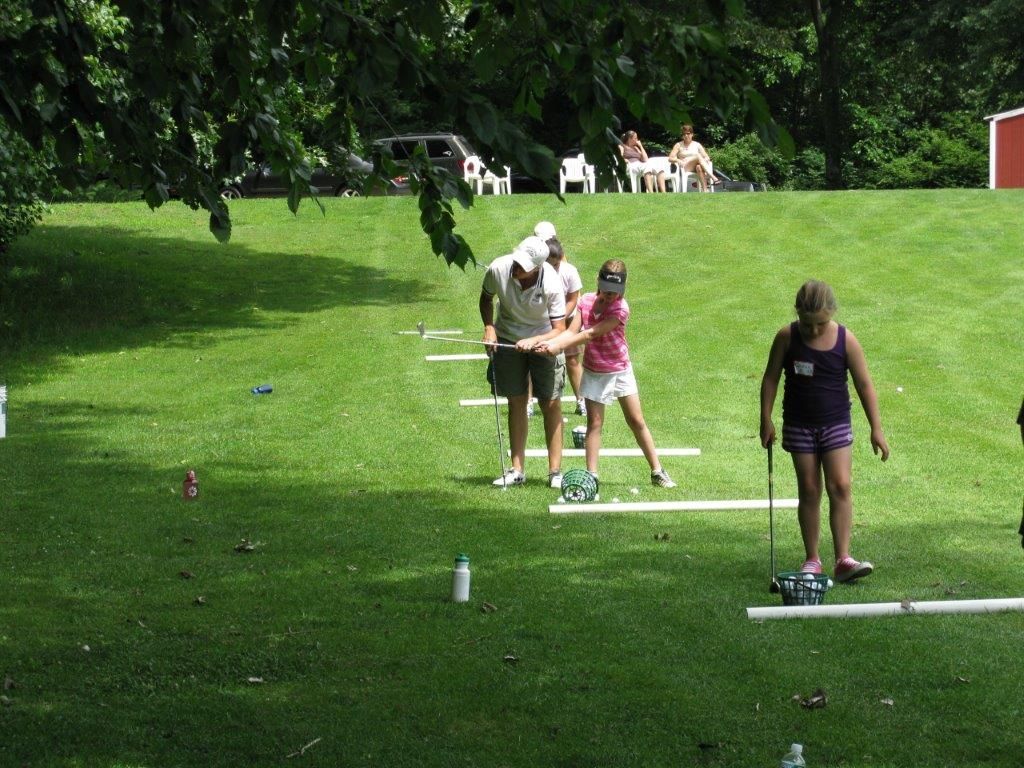 A group of people are playing a game of golf on a lush green field.