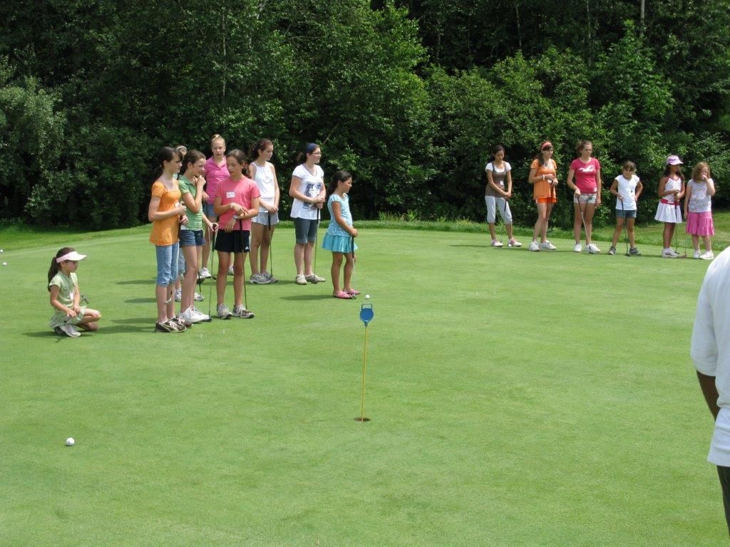 A group of people are standing on a golf course