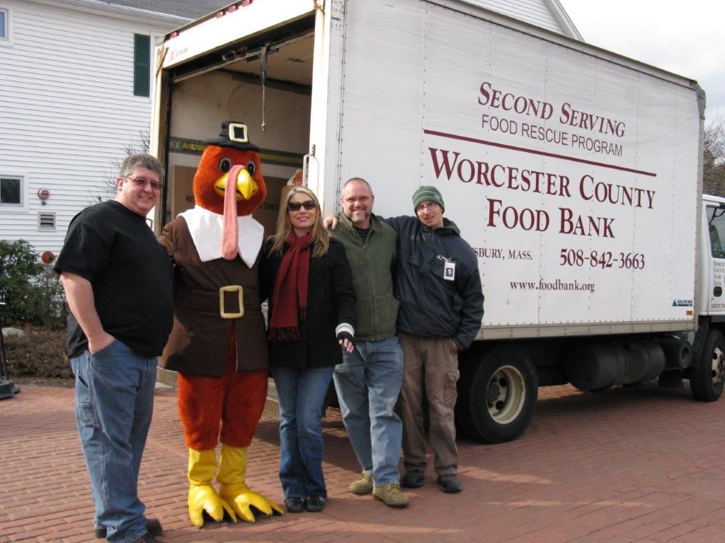 A group of people standing in front of a worcester county food bank truck