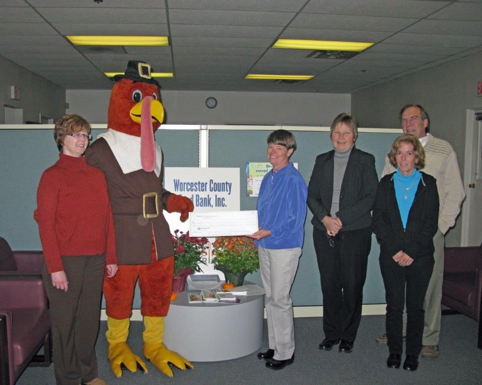 A group of people standing in front of a worcester county bank sign