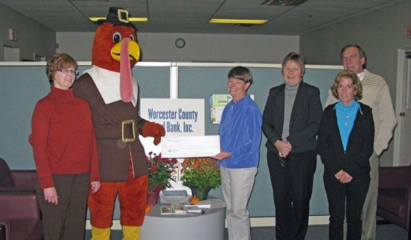 A group of people standing in front of a vermont county bank sign