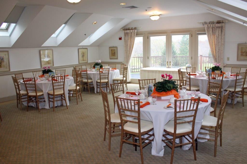A large room with tables and chairs set up for a party