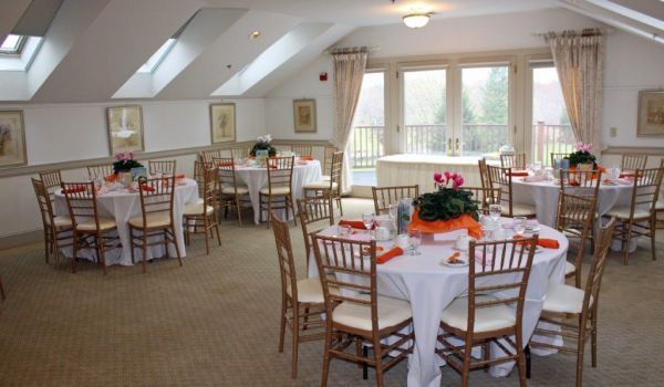 A large room with tables and chairs set up for a party