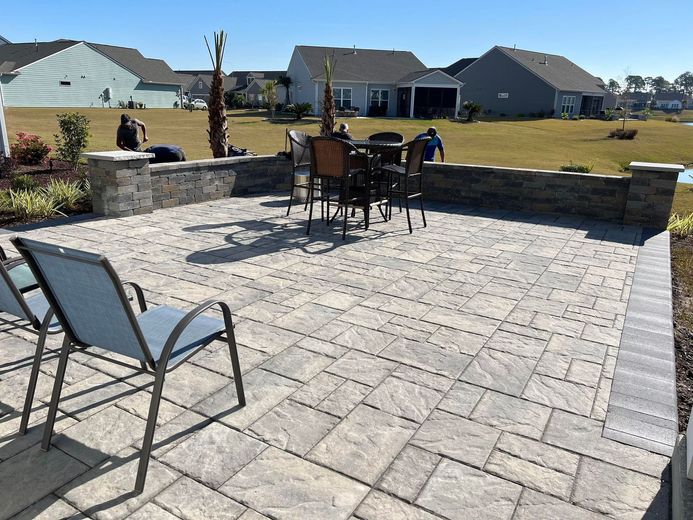 There is a patio with a table and chairs on it.