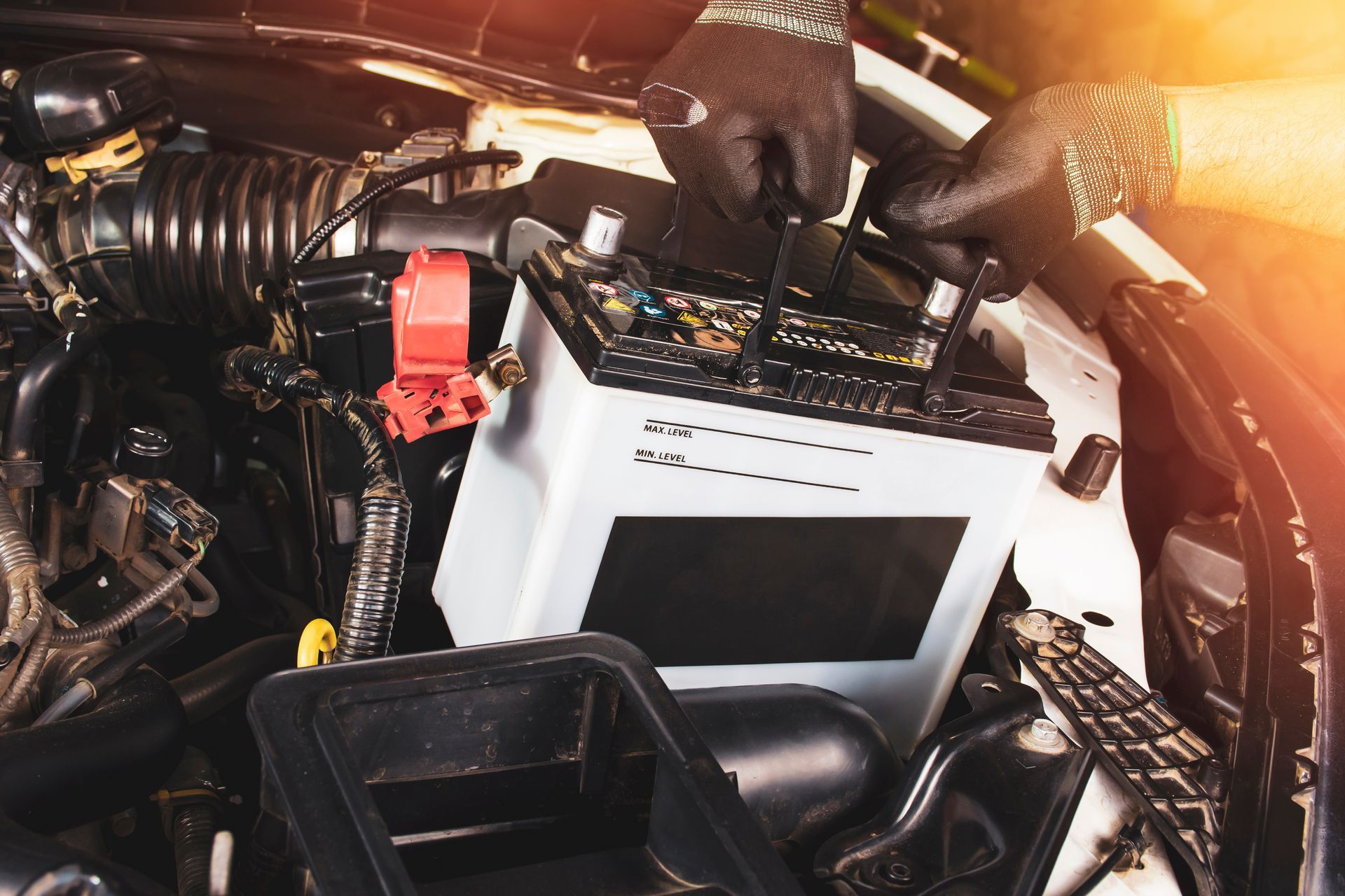 A person is fixing a car battery with a wrench.