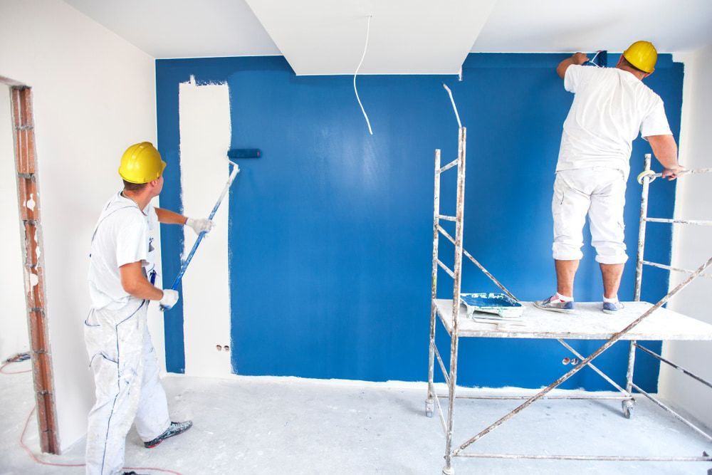 Two Men Are Painting A Blue Wall In A Room — Strait Edge Painting In Tweed Heads South, NSW