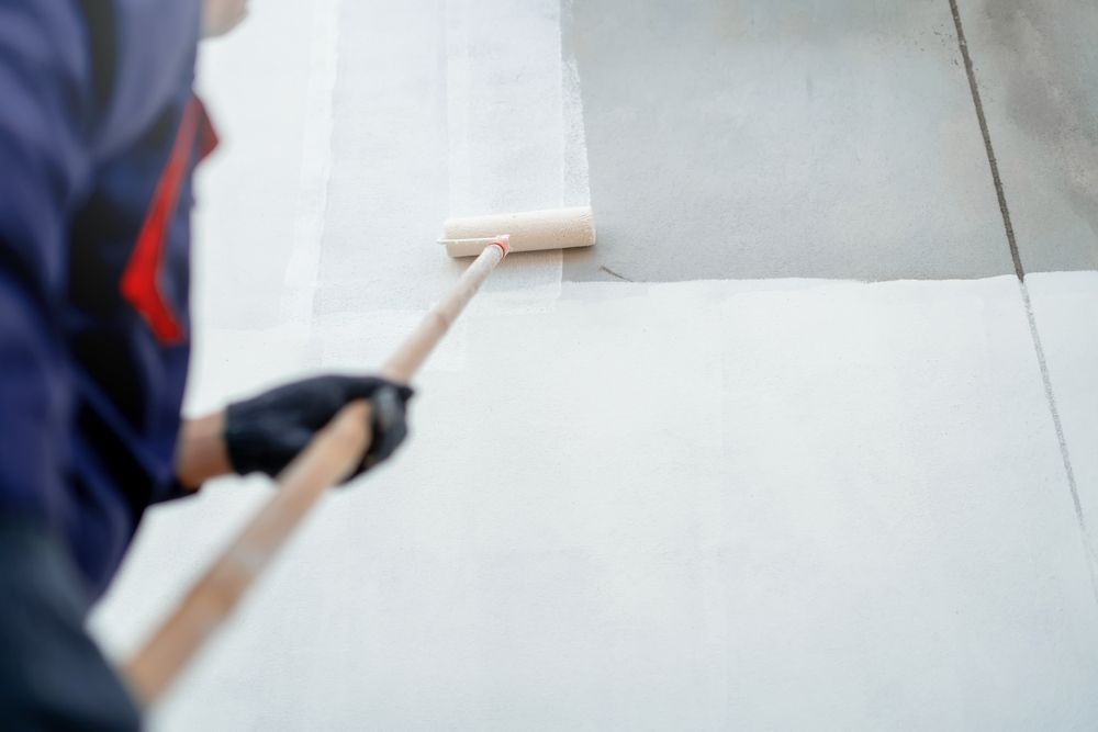 A Person Wearing Black Gloves Uses a Long-handled Roller — Strait Edge Painting In Tweed Heads, NSW
