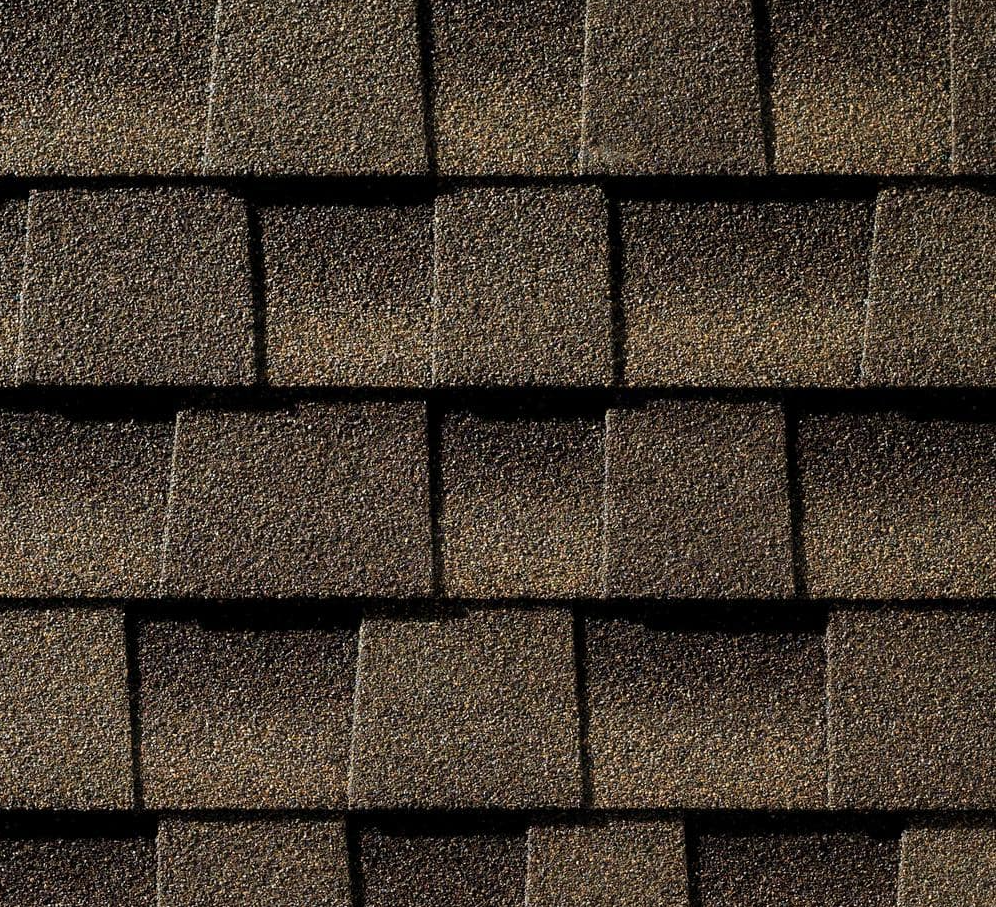 Close-up of overlapping brown asphalt roof shingles.