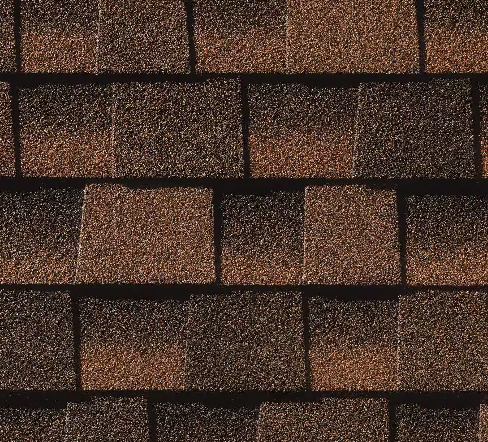 Close-up of overlapping brown and tan asphalt roof shingles.