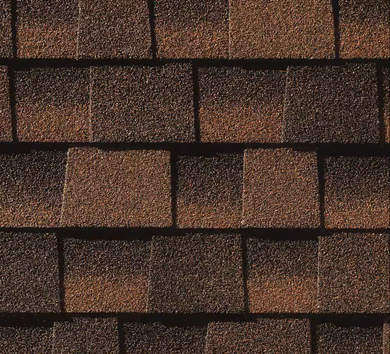 Close-up of overlapping brown and tan asphalt roof shingles.