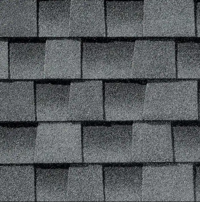Close-up of overlapping gray asphalt roof shingles with varying shades and textures.