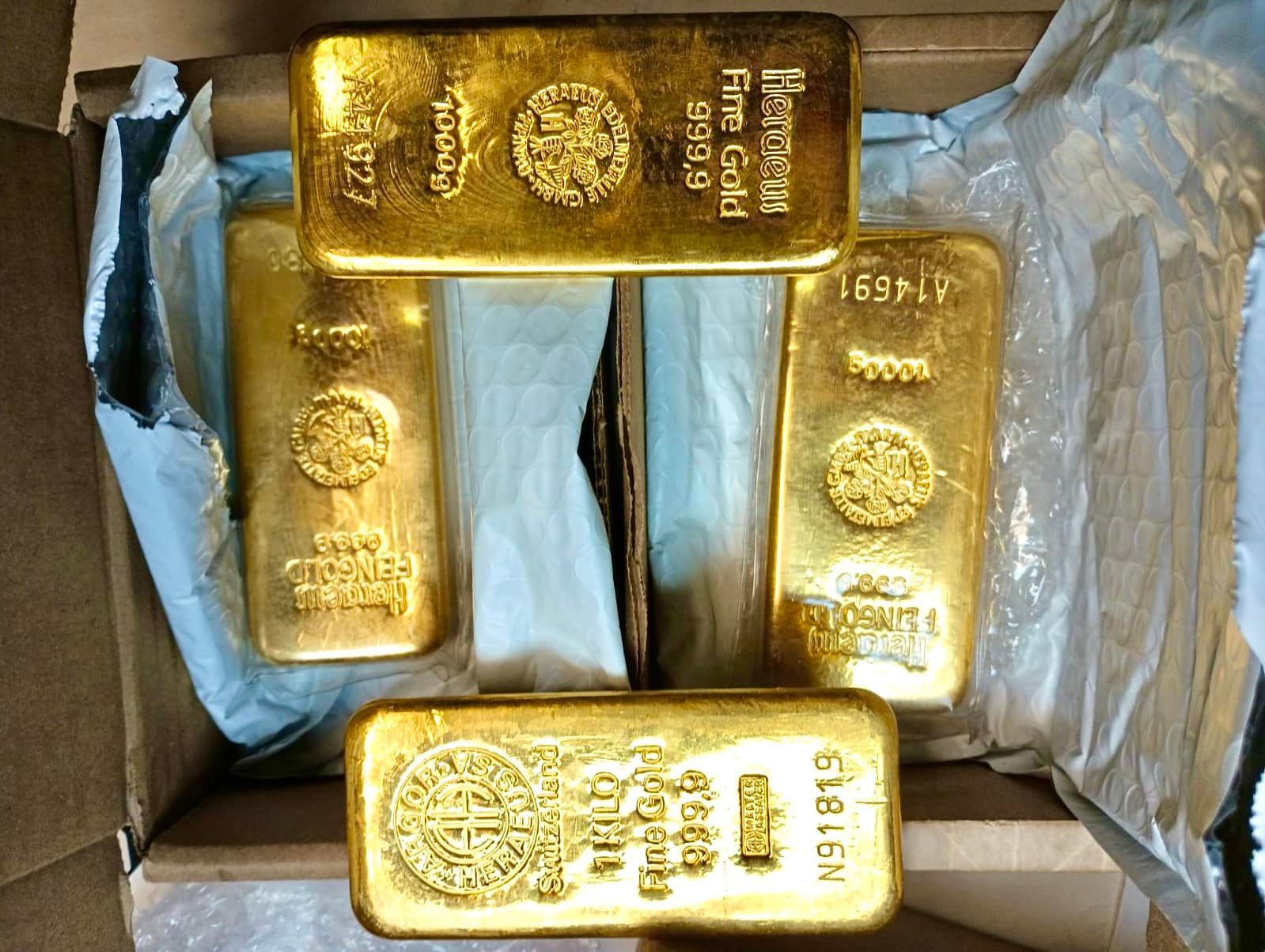 Four gold bars are sitting in a cardboard box