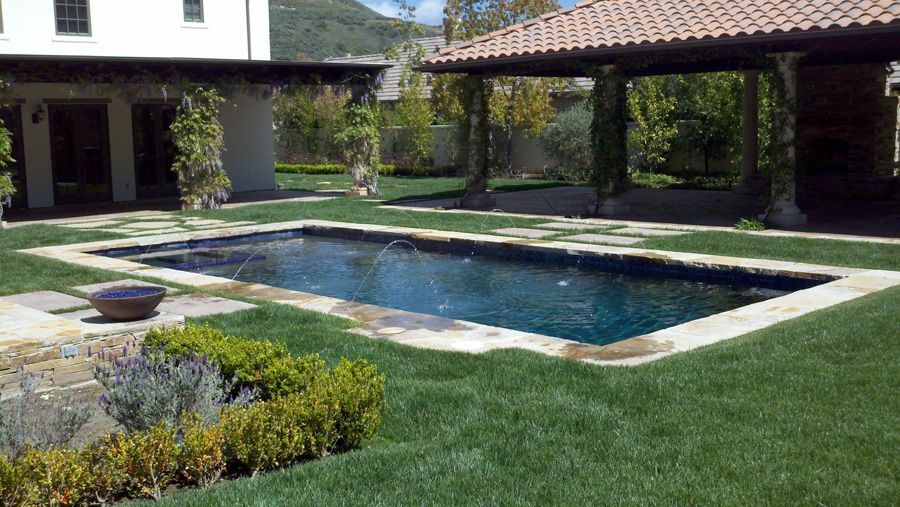 A large swimming pool in the backyard of a house