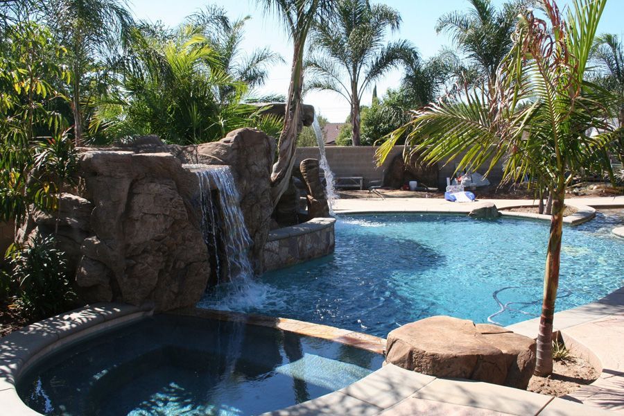 A large swimming pool with a waterfall in the middle