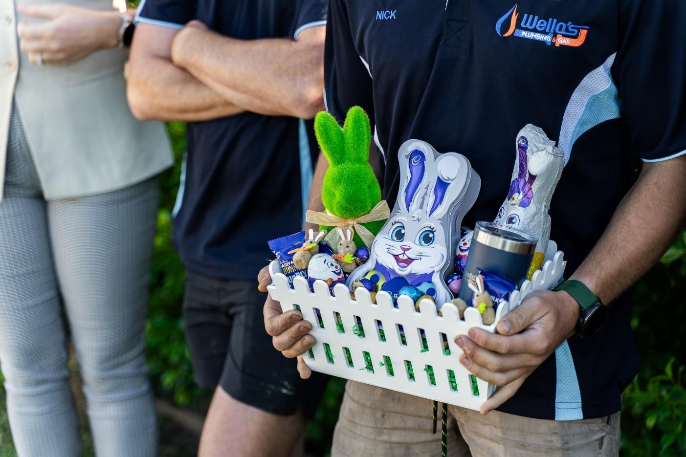 A Man is Holding a Basket With a Bunny on It — Wello's Plumbing & Gas In Thurgoona, NSW