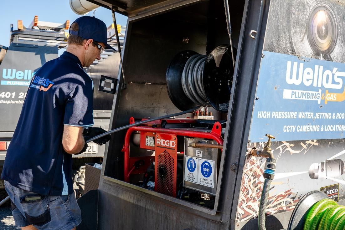 A Man is Working on a Machine in the Back of a Truck — Wello's Plumbing & Gas In Thurgoona, NSW