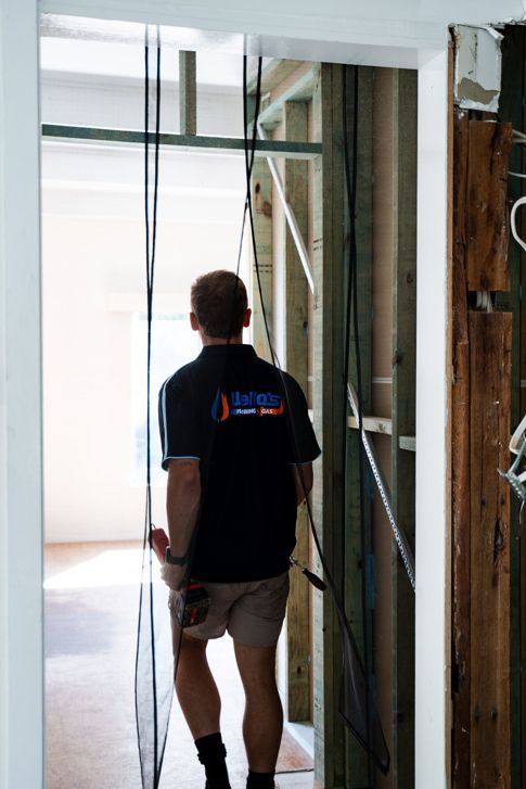 A Man Wearing a Shirt That Says Electrical — Wello's Plumbing & Gas In Thurgoona, NSW