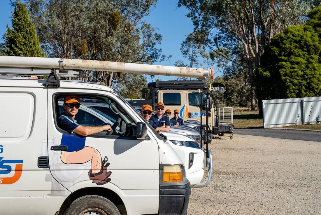 A Man is Sitting in the Driver's Seat of a White Van — Wello's Plumbing & Gas In Thurgoona, NSW