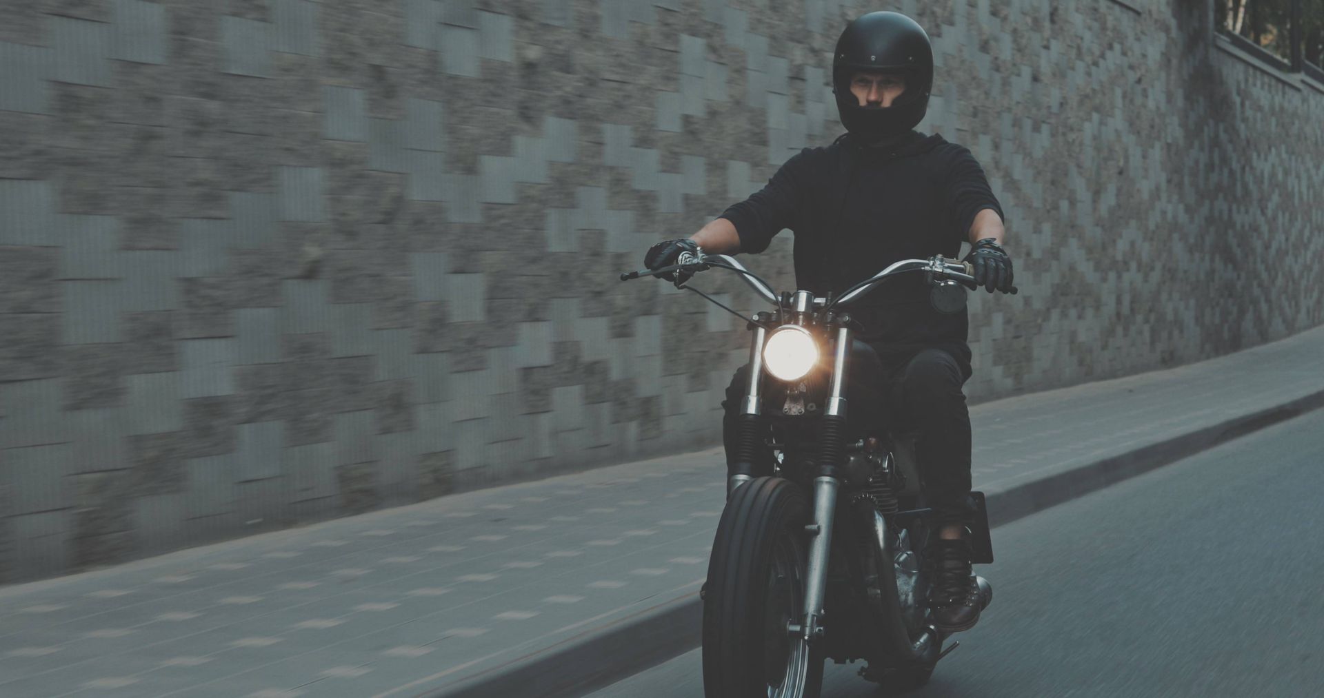 A man is riding a motorcycle down a street.