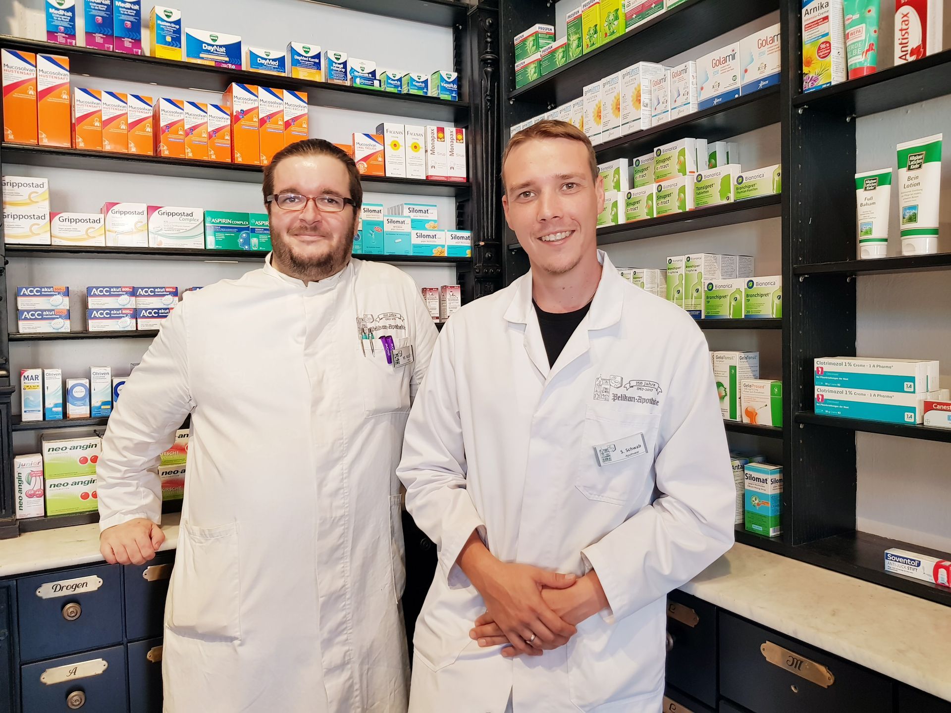 Eine Frau öffnet in einer Apotheke eine Schublade.