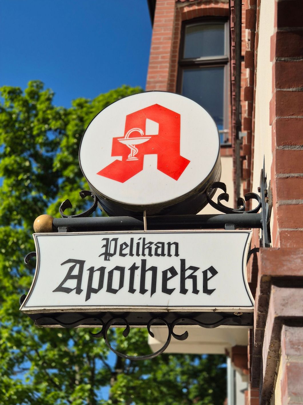 Ein Schild der Pelikan-Apotheke hängt an der Seite eines Gebäudes