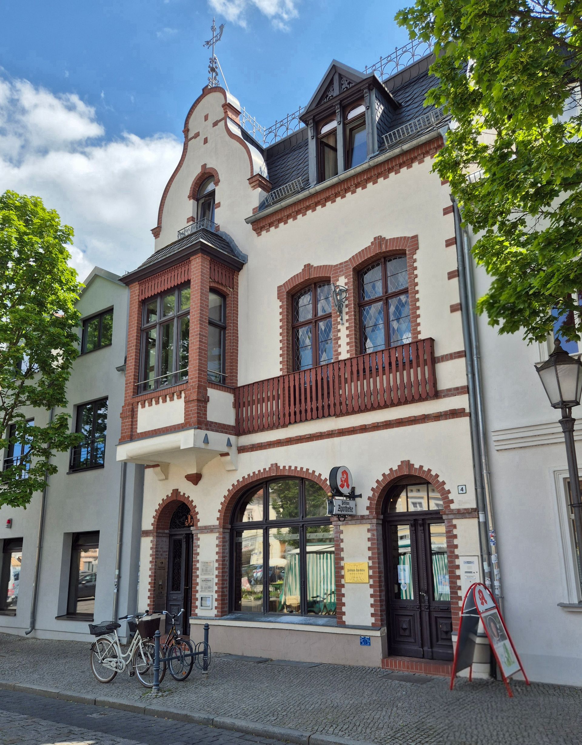 Ein großes Gebäude mit einem Balkon und davor abgestellten Fahrrädern