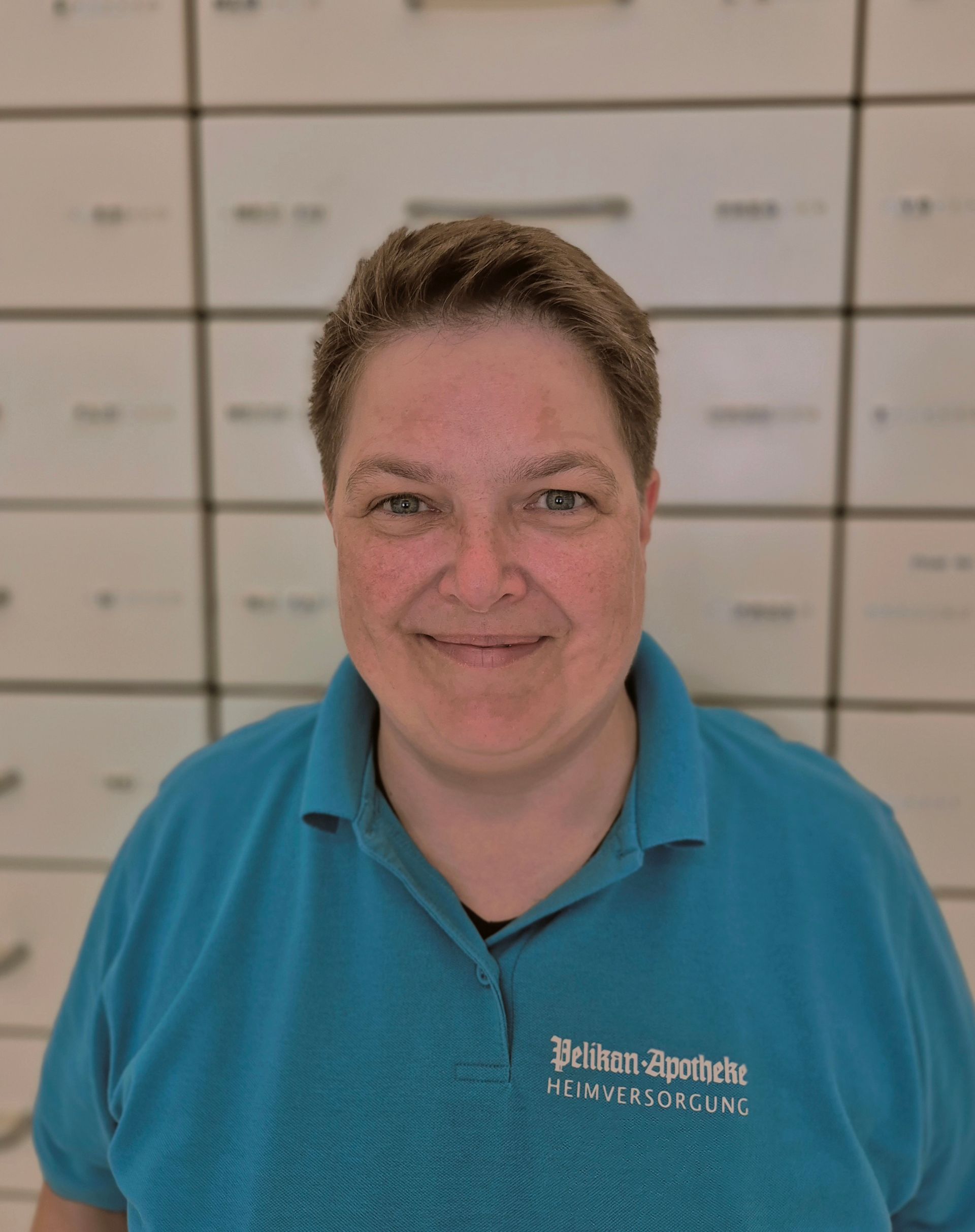 Ein junger Mann mit Schal und Pullover steht im Schnee.