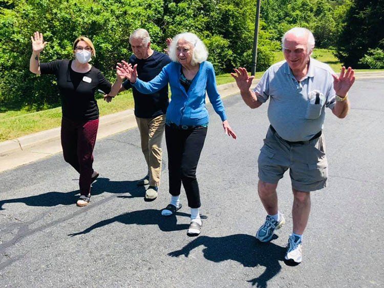 A group of people are walking down a street with their hands in the air.