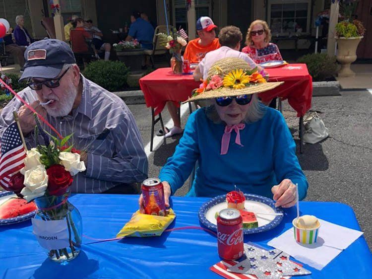 A man and a woman are sitting at a table eating food.