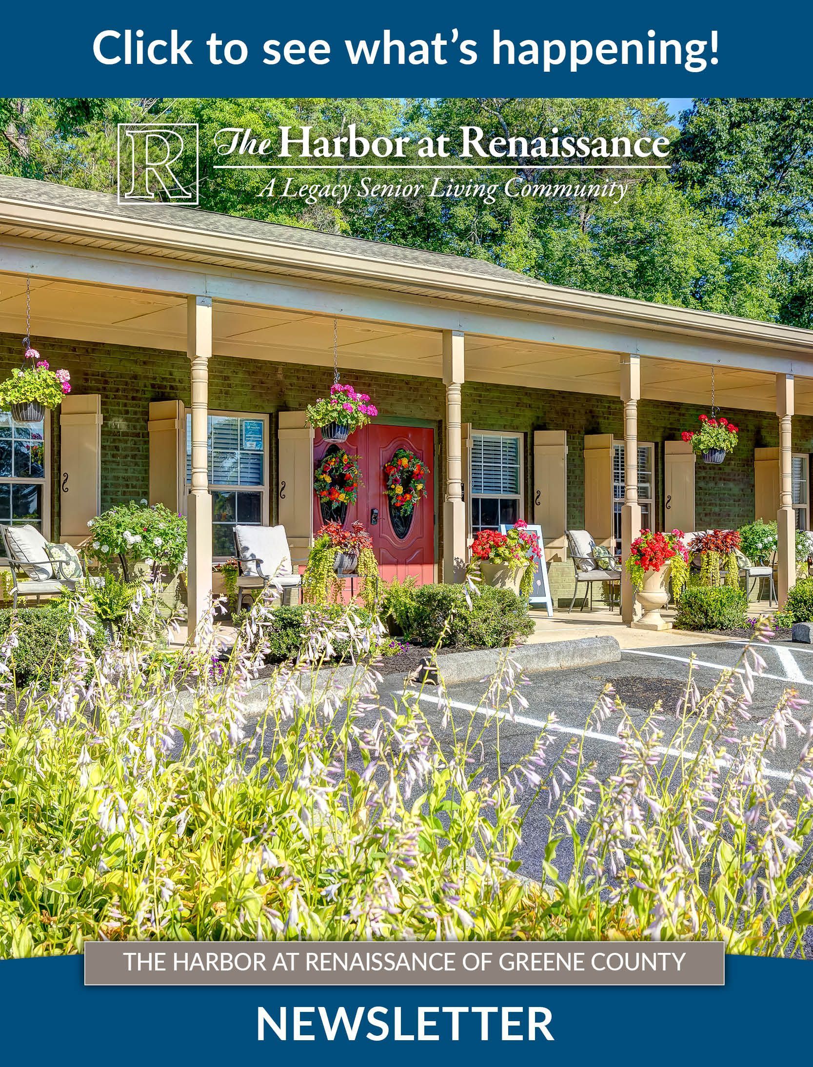 A house with a porch and flowers in front of it.