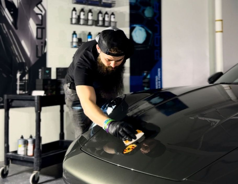 A man is polishing the hood of a car