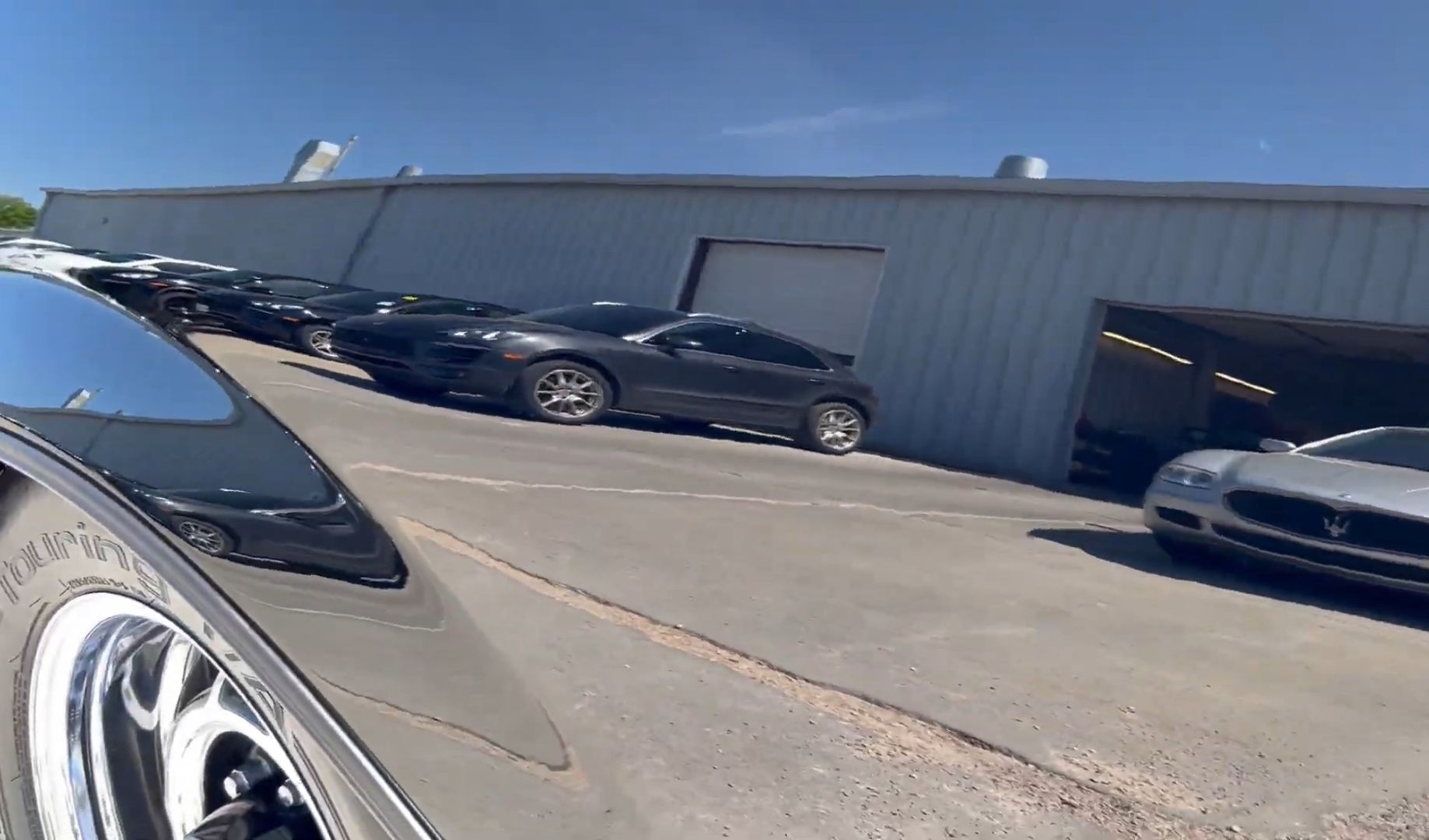 A row of cars are parked in front of a building.
