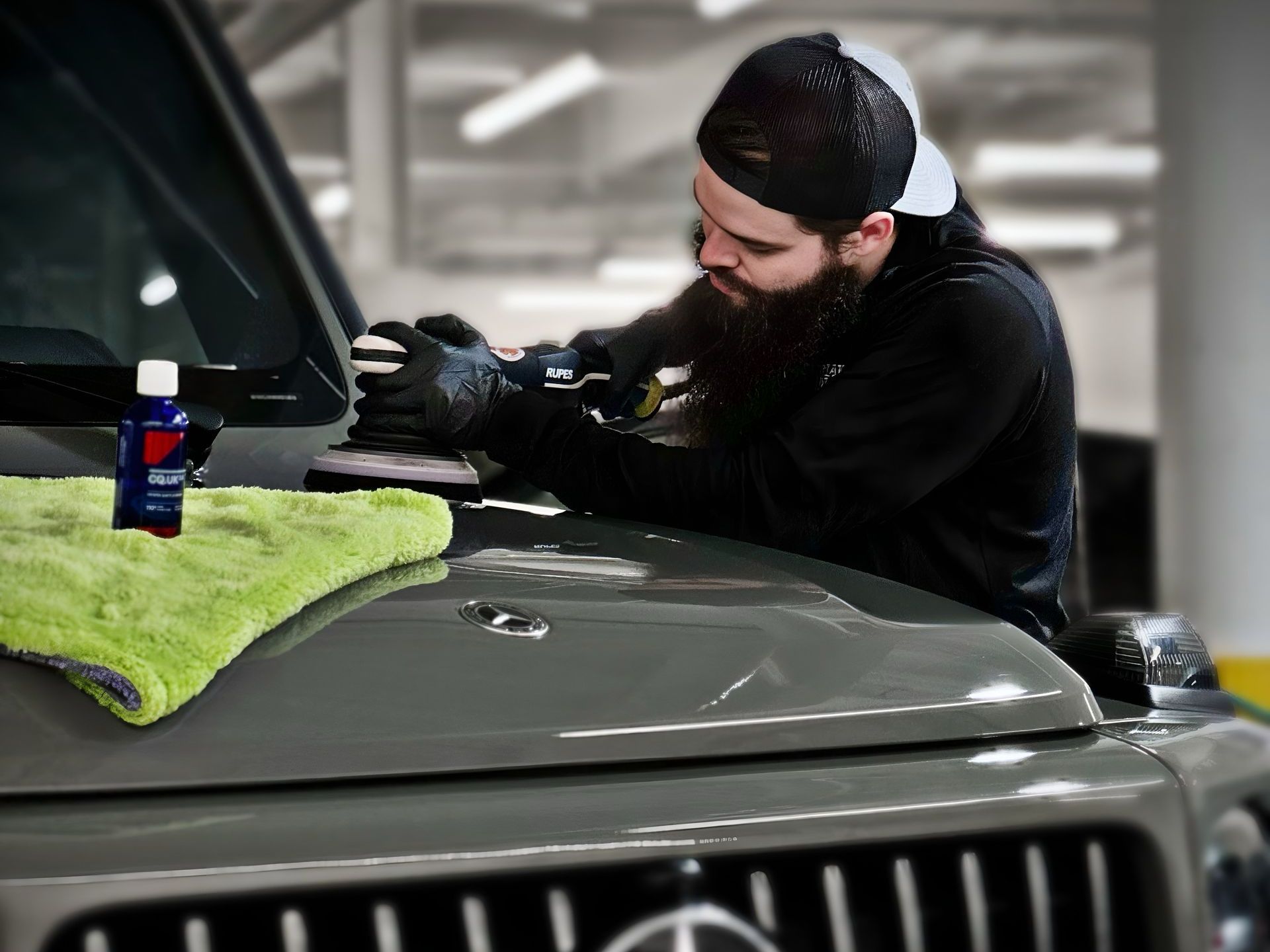 A close up of a red car 's fender with a green cloth on it.