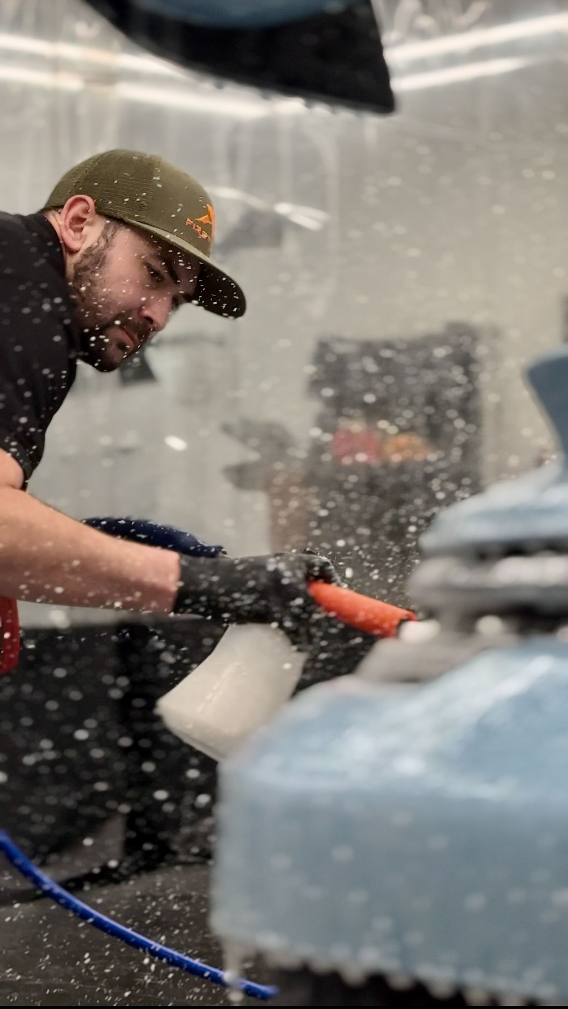 A man is cleaning a car with a spray bottle.