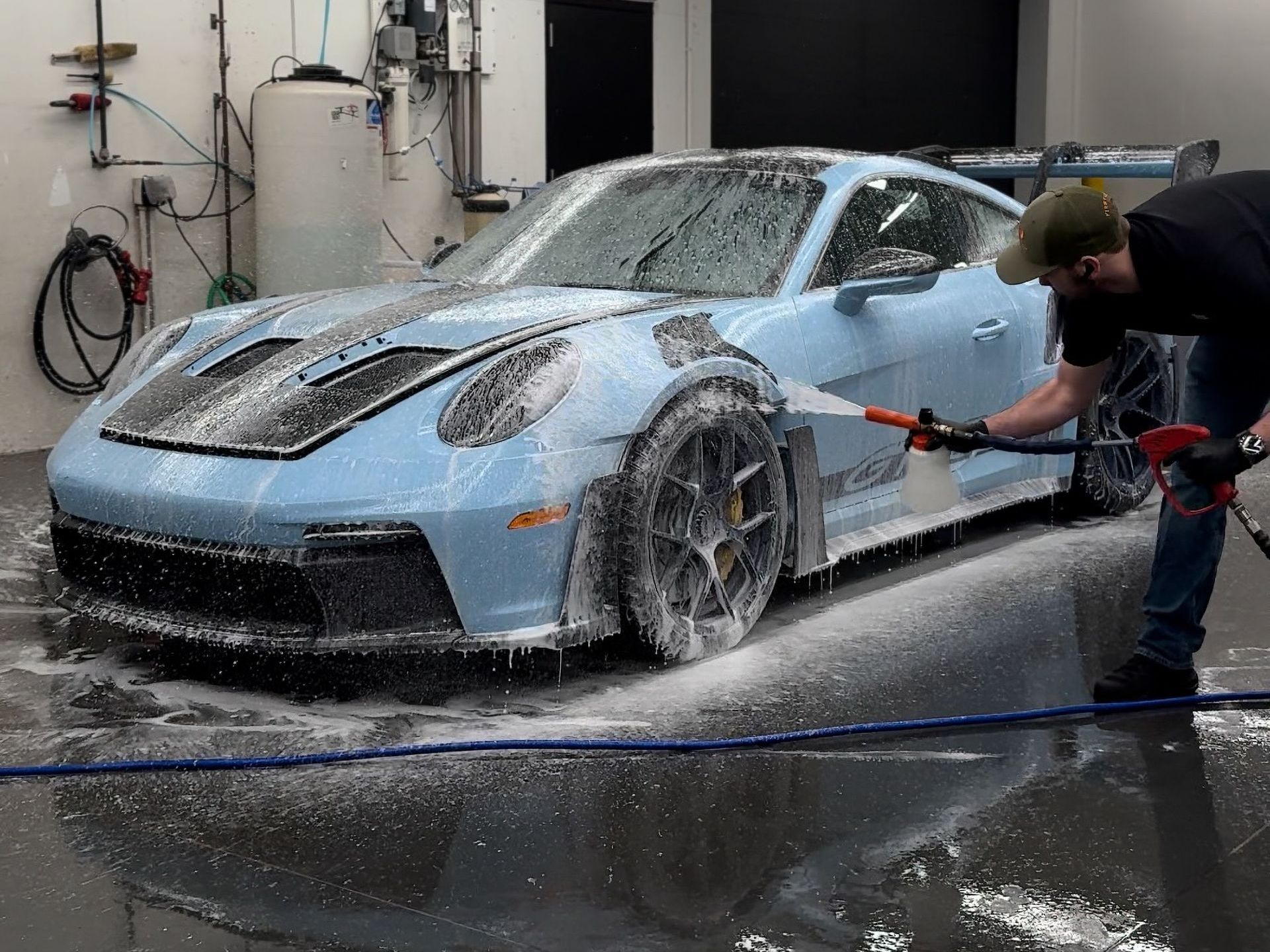 A group of people are working on a car in a garage.