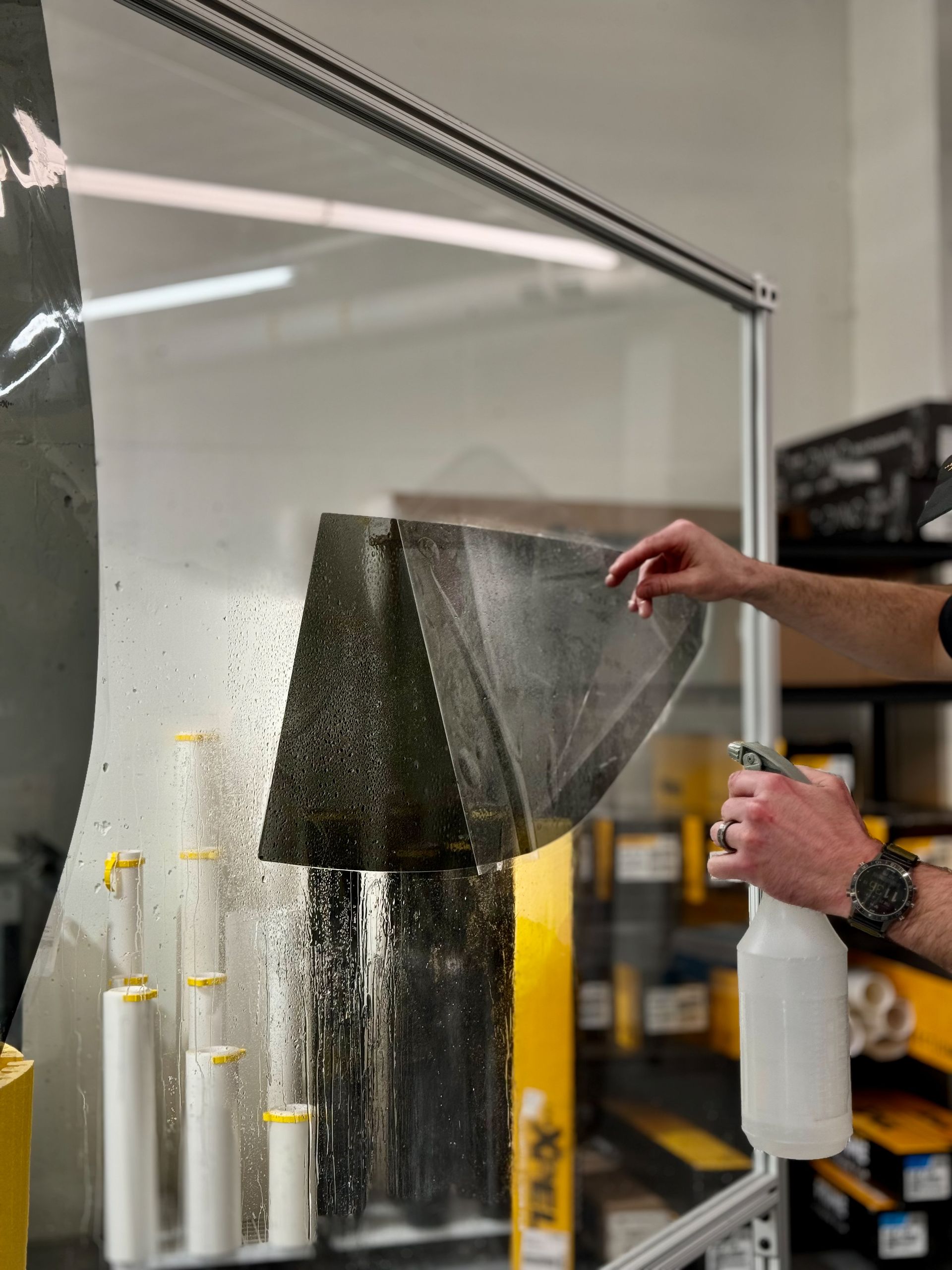 A person is cleaning a window with a spray bottle.