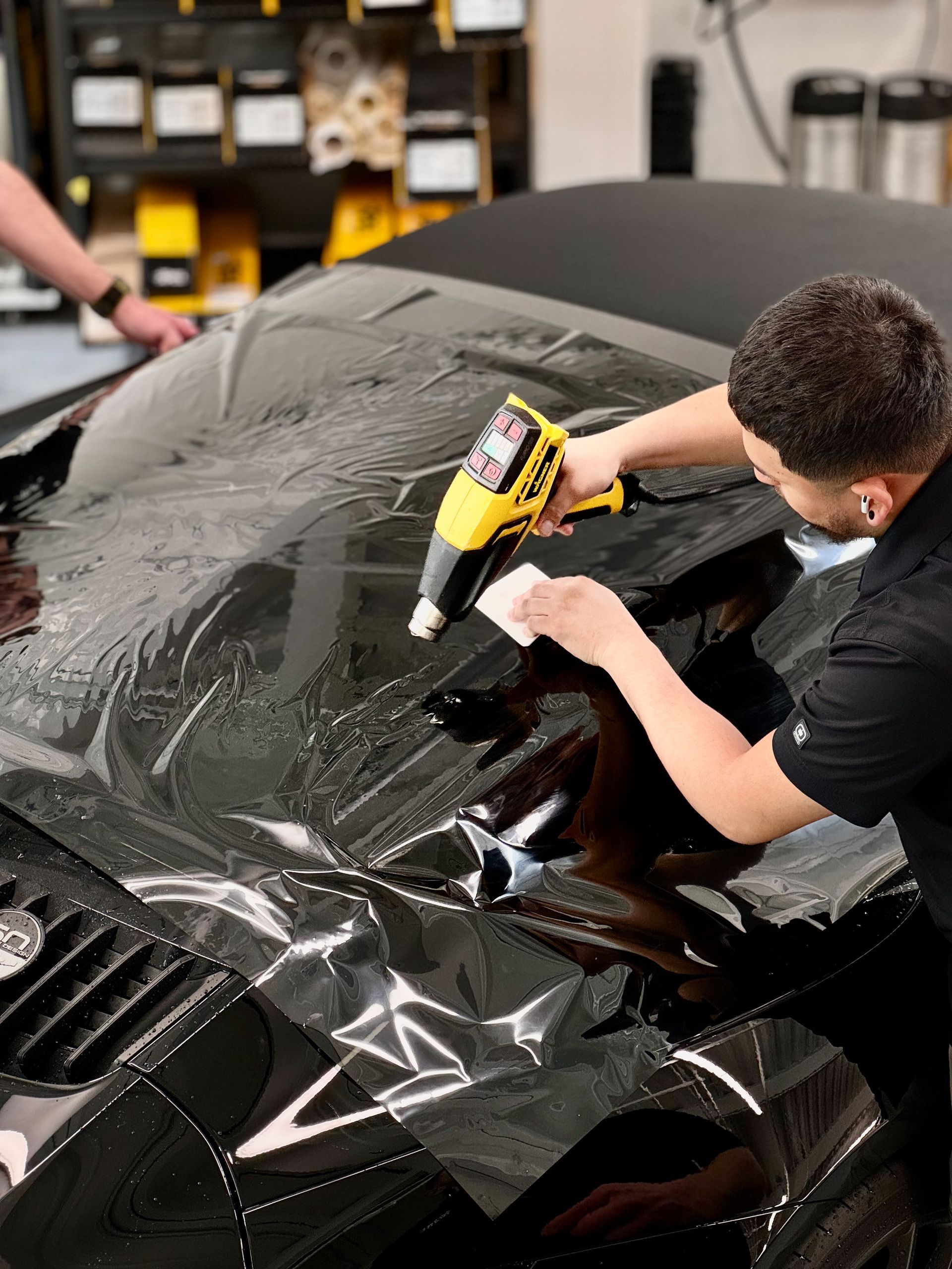 Man window tinting a Porsche Targa
