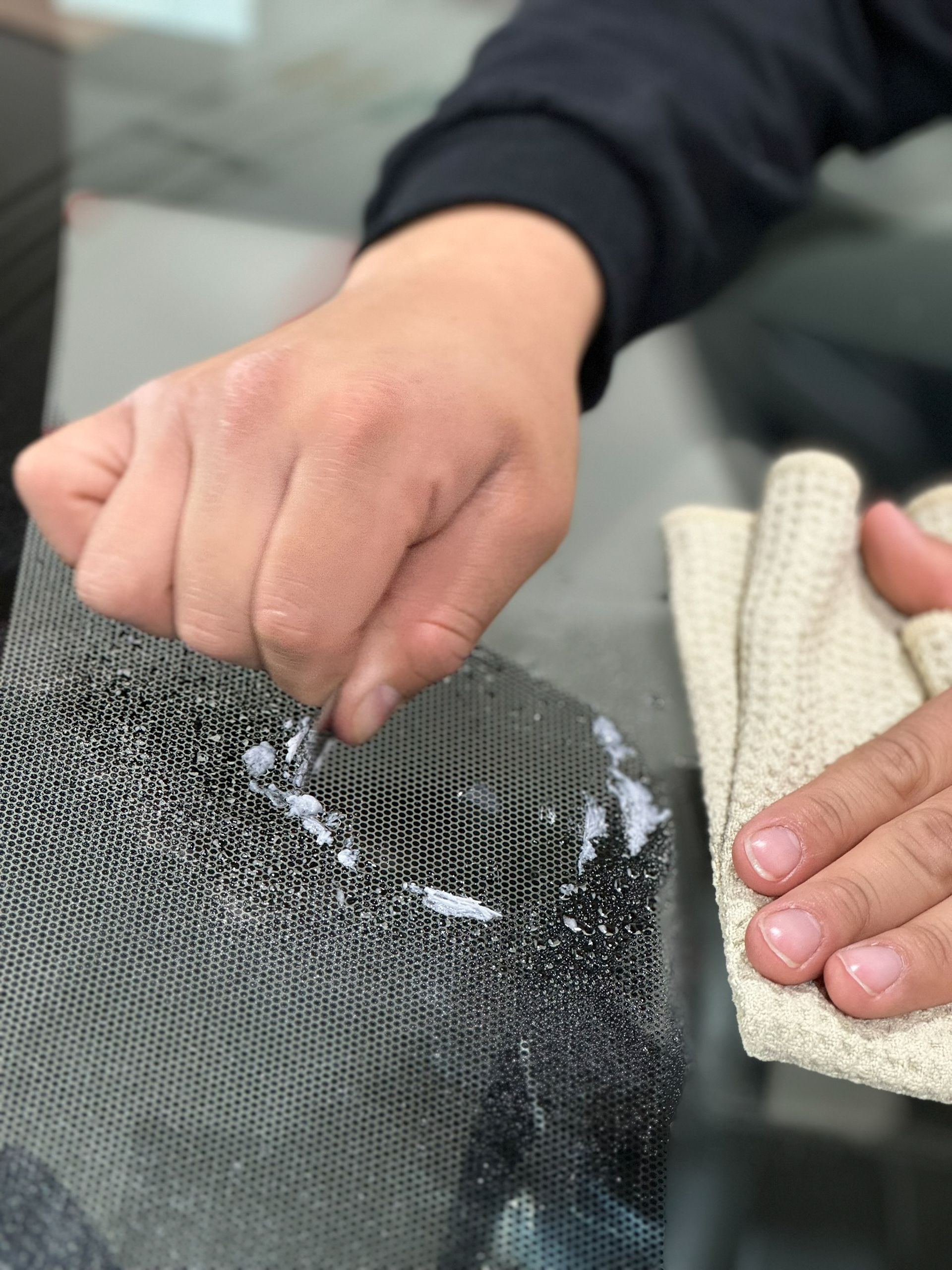 A person is cleaning a glass surface with a cloth